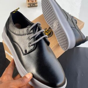 Dr. Martens black leather shoes with patterned laces and gray sole